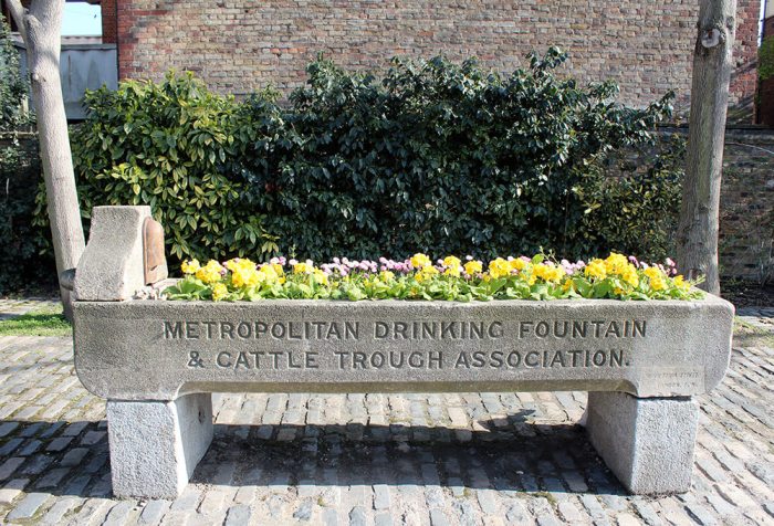 Old London stone water trough to provide water for animals - now filled with flowers
