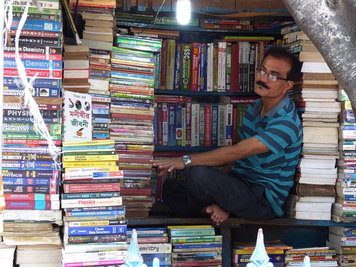 Book seller sits in his stall surrounded by books