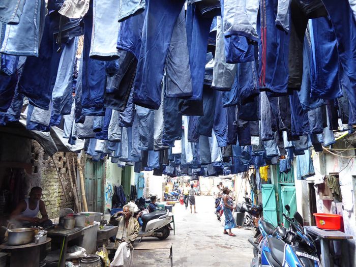 Rows of jeans hanging above a Kolkata back-steet